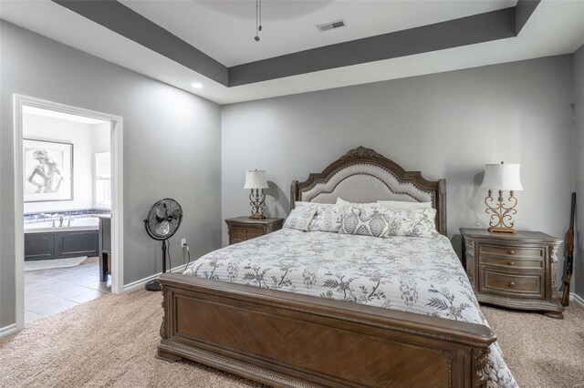 bedroom featuring visible vents, baseboards, light carpet, recessed lighting, and ensuite bath