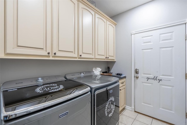 laundry room with light tile patterned floors, washing machine and dryer, and cabinet space