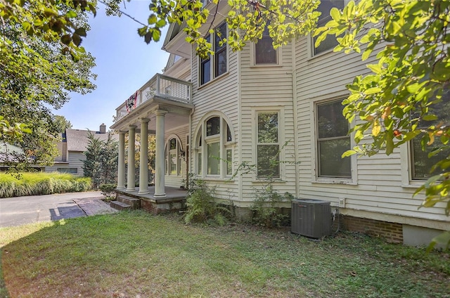 view of front of property featuring a front lawn and central air condition unit