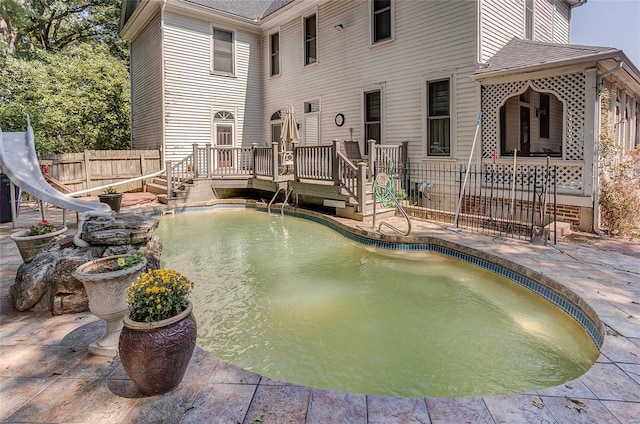 view of pool featuring a water slide and a patio area