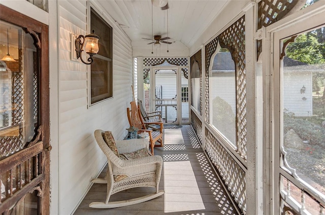 sunroom / solarium with lofted ceiling, a healthy amount of sunlight, and ceiling fan