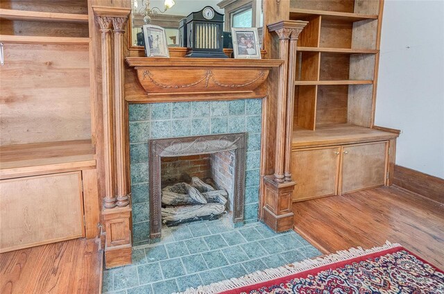 interior details featuring a fireplace, hardwood / wood-style flooring, and ornate columns