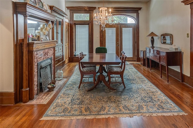 dining area with wood-type flooring, a chandelier, and french doors