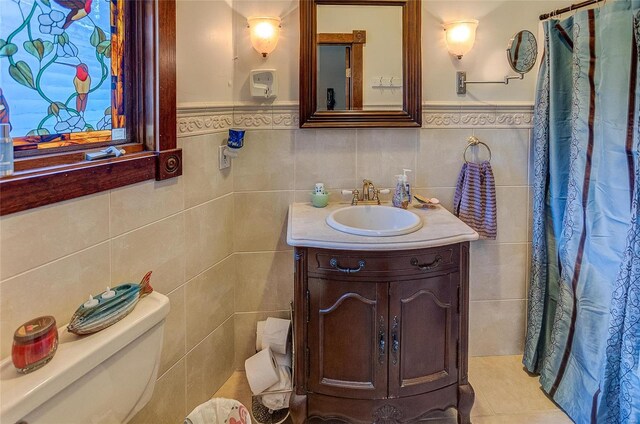 bathroom featuring vanity, tile walls, toilet, and tile patterned flooring