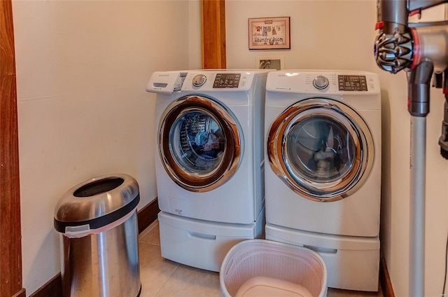 clothes washing area with washing machine and dryer and light tile patterned flooring