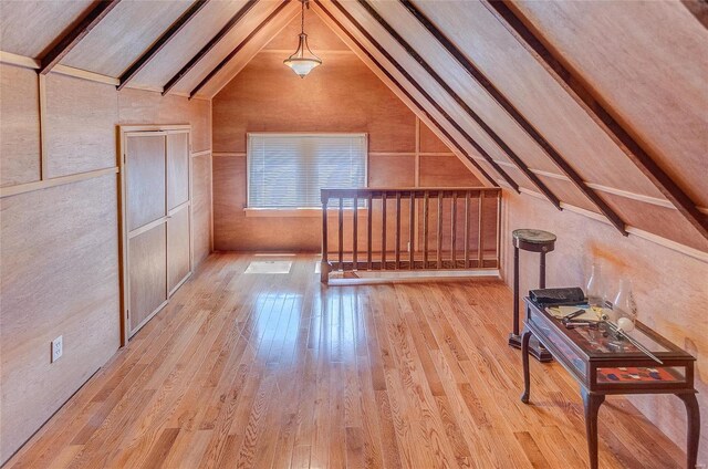 bonus room featuring lofted ceiling and light hardwood / wood-style flooring