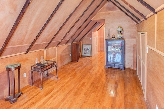 additional living space featuring vaulted ceiling and hardwood / wood-style flooring