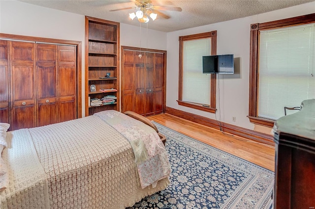 bedroom with a textured ceiling, ceiling fan, and hardwood / wood-style floors