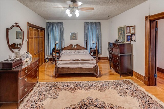 bedroom featuring a textured ceiling, ceiling fan, and light wood-type flooring