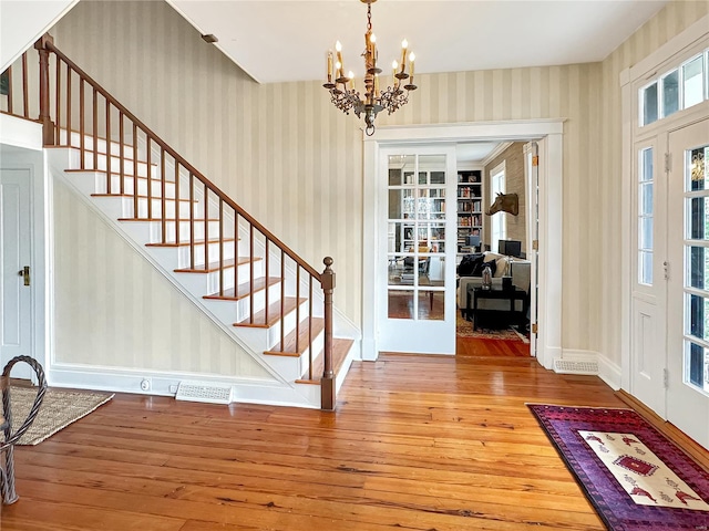 foyer with hardwood / wood-style floors and an inviting chandelier