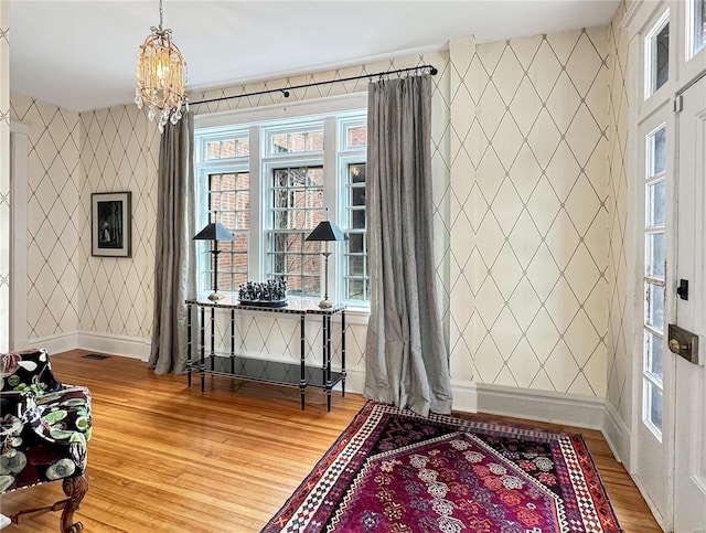 entryway with light hardwood / wood-style flooring and an inviting chandelier