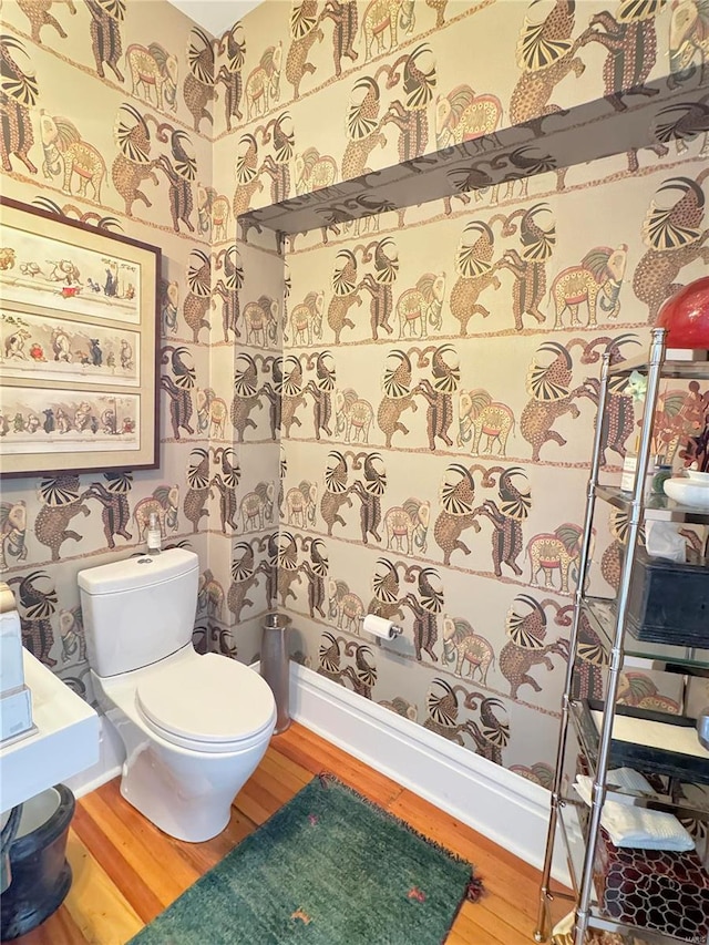 bathroom with toilet and hardwood / wood-style flooring