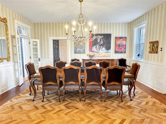 dining room featuring light parquet flooring and an inviting chandelier