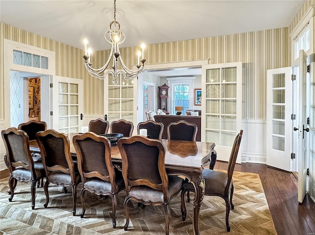 dining space featuring french doors, parquet flooring, and a notable chandelier