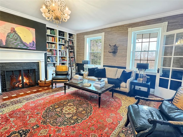 living room featuring crown molding, a brick fireplace, built in shelves, and a notable chandelier