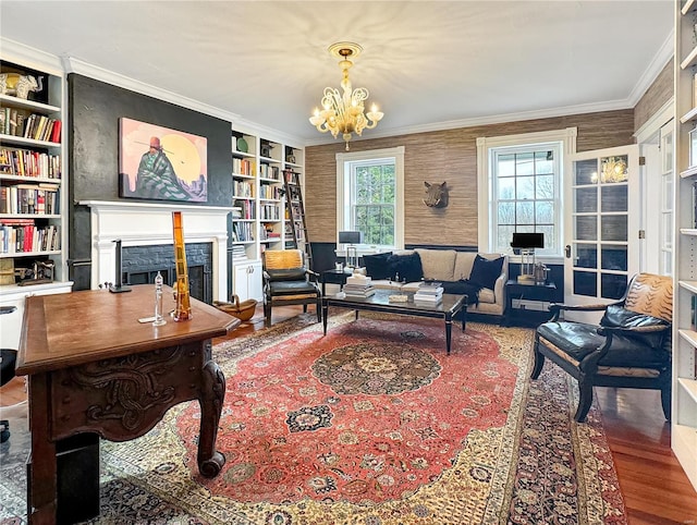 office space featuring built in shelves, ornamental molding, wood-type flooring, and a notable chandelier