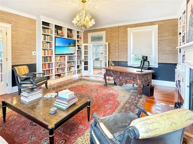 sitting room with built in features, ornamental molding, hardwood / wood-style floors, and an inviting chandelier