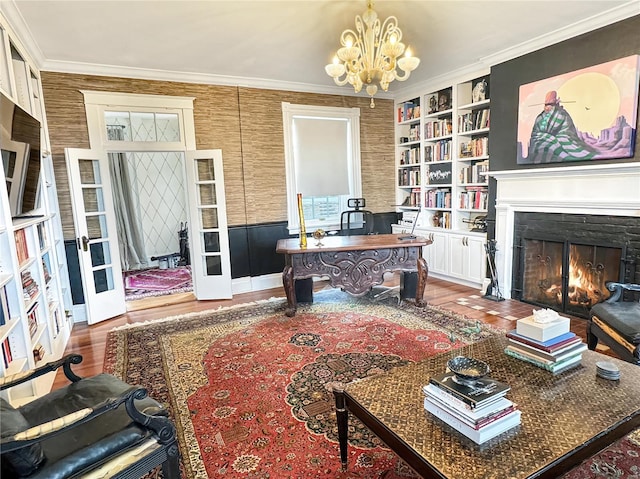 interior space featuring built in shelves, ornamental molding, a chandelier, and hardwood / wood-style flooring