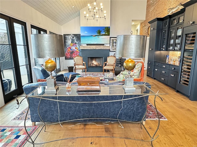 living room with beverage cooler, high vaulted ceiling, a notable chandelier, and light hardwood / wood-style flooring