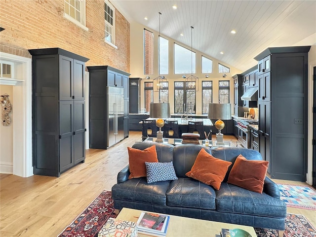 living room featuring high vaulted ceiling and light hardwood / wood-style floors