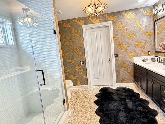 bathroom featuring vanity, an inviting chandelier, walk in shower, toilet, and tile patterned floors