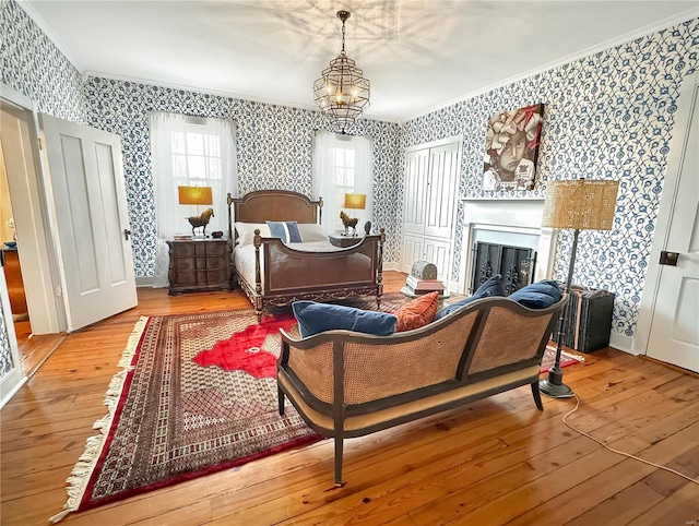 bedroom with crown molding, hardwood / wood-style floors, and a chandelier