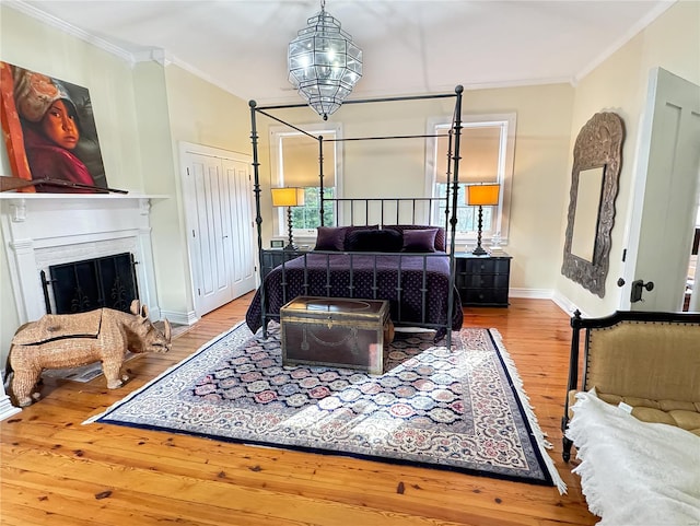 bedroom with ornamental molding and hardwood / wood-style floors