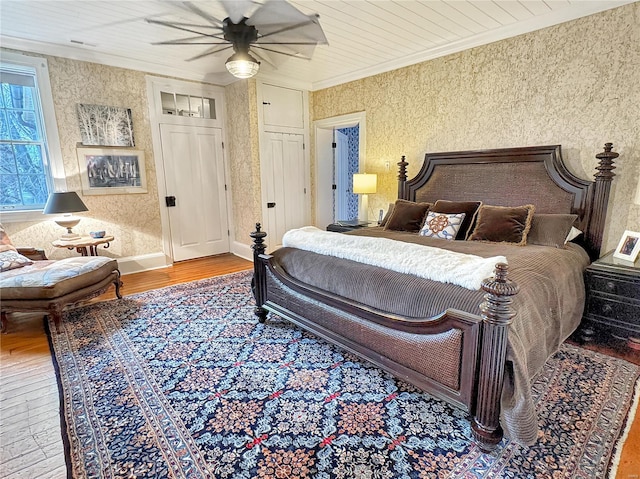 bedroom featuring hardwood / wood-style floors, ceiling fan, and crown molding