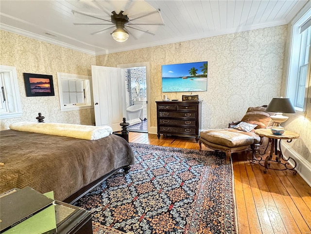 bedroom with crown molding, ceiling fan, ensuite bath, and hardwood / wood-style flooring