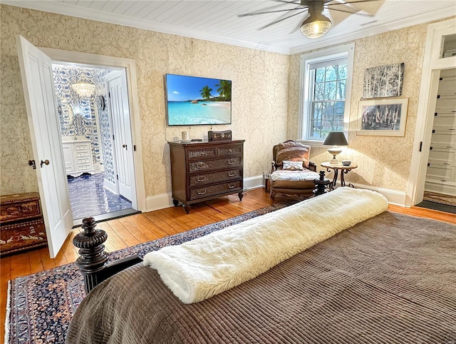 bedroom with crown molding, ceiling fan, and wood-type flooring