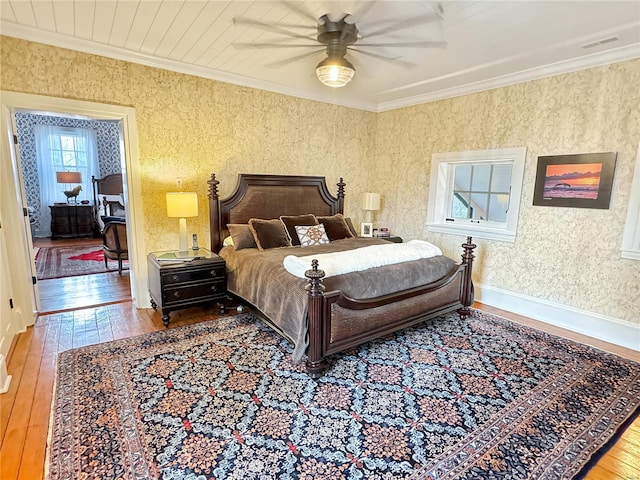 bedroom featuring ceiling fan, hardwood / wood-style flooring, and crown molding