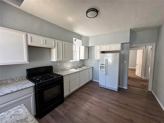 kitchen featuring white refrigerator with ice dispenser, dark wood-type flooring, sink, white cabinetry, and black gas range