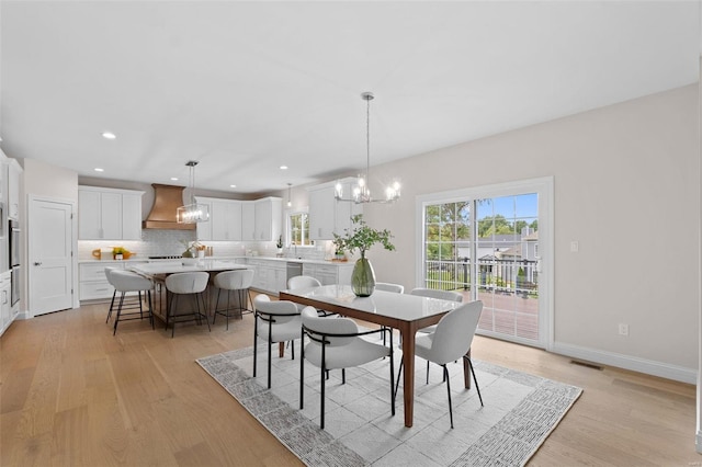 dining area with a notable chandelier and light hardwood / wood-style floors