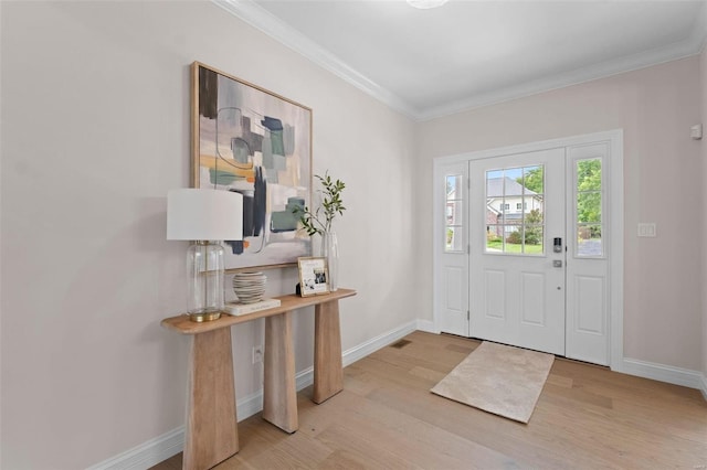 foyer featuring ornamental molding and light hardwood / wood-style flooring