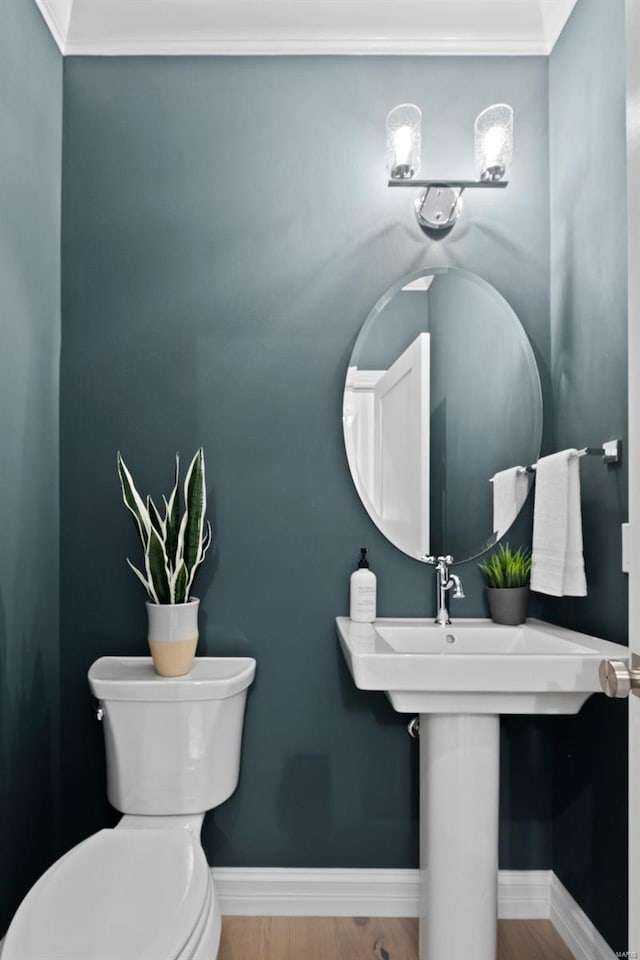 bathroom featuring ornamental molding, toilet, and hardwood / wood-style flooring