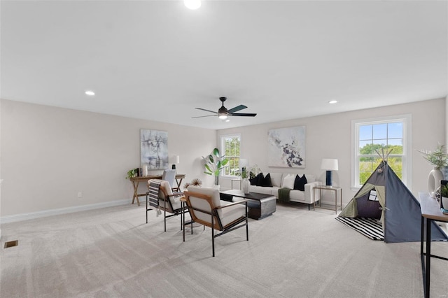 living room featuring light colored carpet and ceiling fan