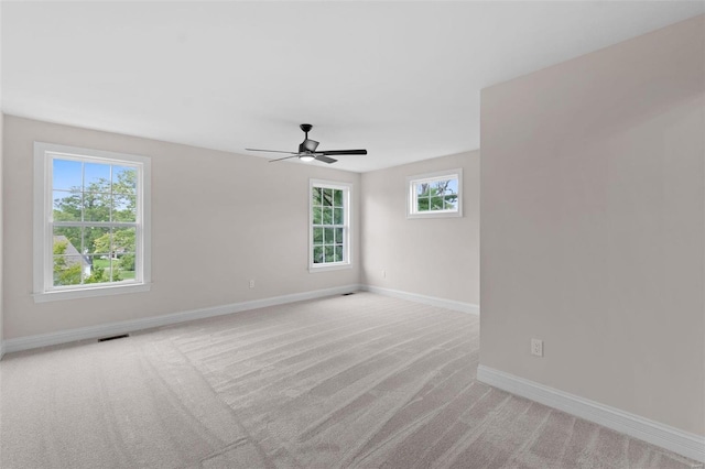 spare room with ceiling fan and light colored carpet