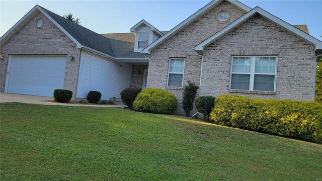 view of front of house with a garage, a front yard, concrete driveway, and brick siding