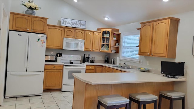 kitchen with white appliances, light tile patterned floors, kitchen peninsula, sink, and vaulted ceiling