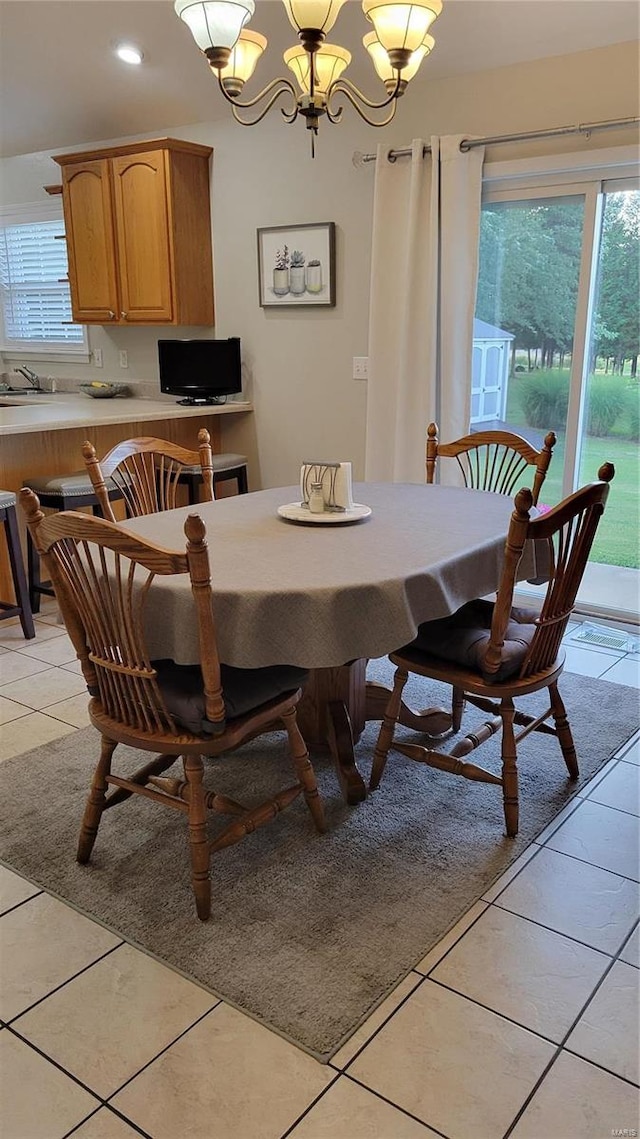 dining space featuring an inviting chandelier and light tile patterned floors