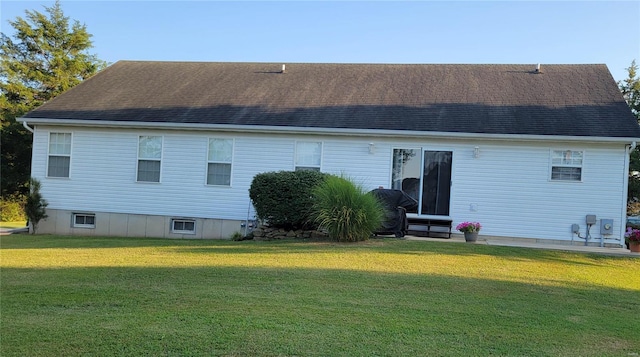 rear view of property featuring a lawn