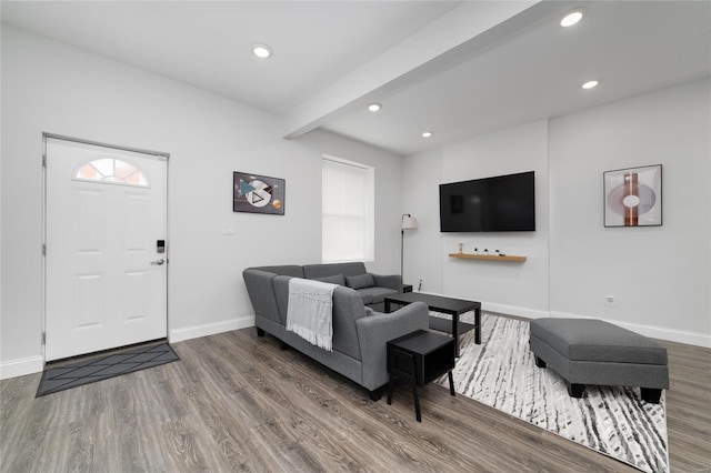 living room featuring beamed ceiling and wood-type flooring