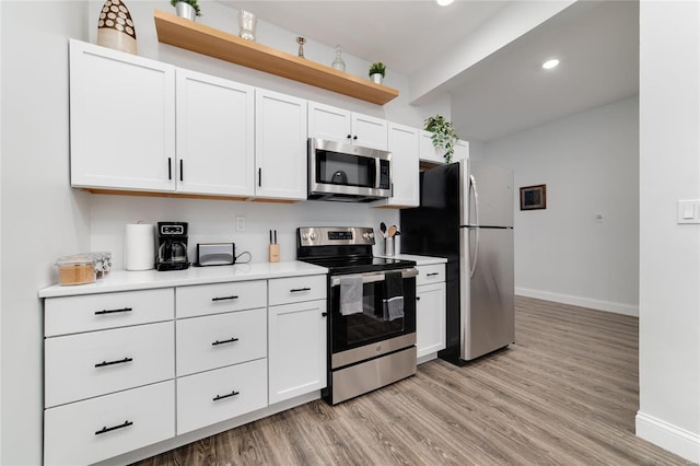 kitchen featuring white cabinetry, appliances with stainless steel finishes, and light hardwood / wood-style flooring