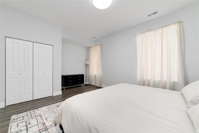 bedroom with a closet and dark hardwood / wood-style floors