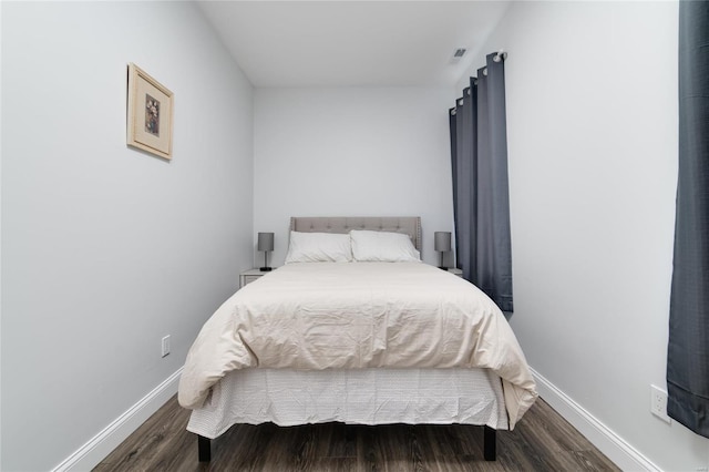 bedroom with dark hardwood / wood-style flooring