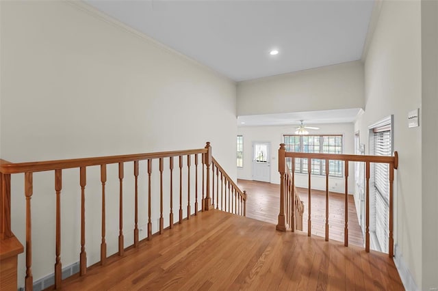 stairs featuring hardwood / wood-style floors, ceiling fan, and ornamental molding