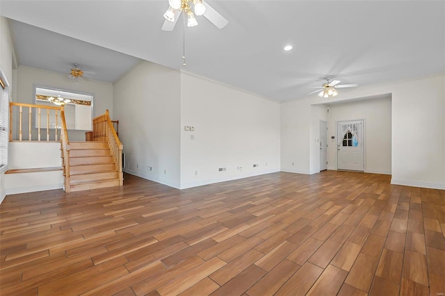 unfurnished living room featuring baseboards, ceiling fan, wood finished floors, and stairway