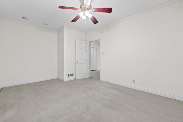 carpeted empty room with ceiling fan and ornamental molding