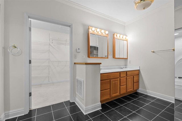 full bathroom with visible vents, baseboards, double vanity, ornamental molding, and tile patterned flooring
