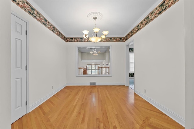 unfurnished dining area featuring a chandelier, light wood-type flooring, and ornamental molding